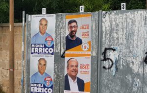 Cose da campagna elettorale: i manifesti abusivi dell’ex Garante della Legalità. Il notaio Errico occupa illegalmente lo spazio riservato al M5S