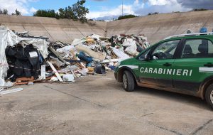 Discarica di rifiuti in una vasca di cemento per la raccolta delle acque